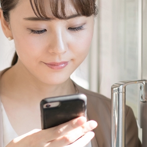 スマホで調べ物をする女性